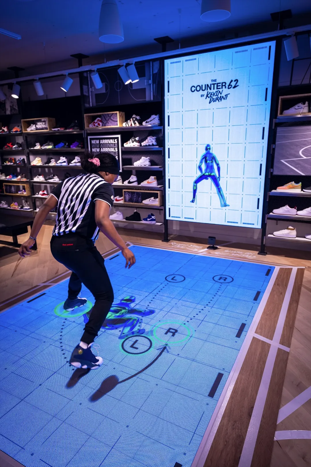 Player jumping on the Famous Footwork projected floor court inside Foot Locker